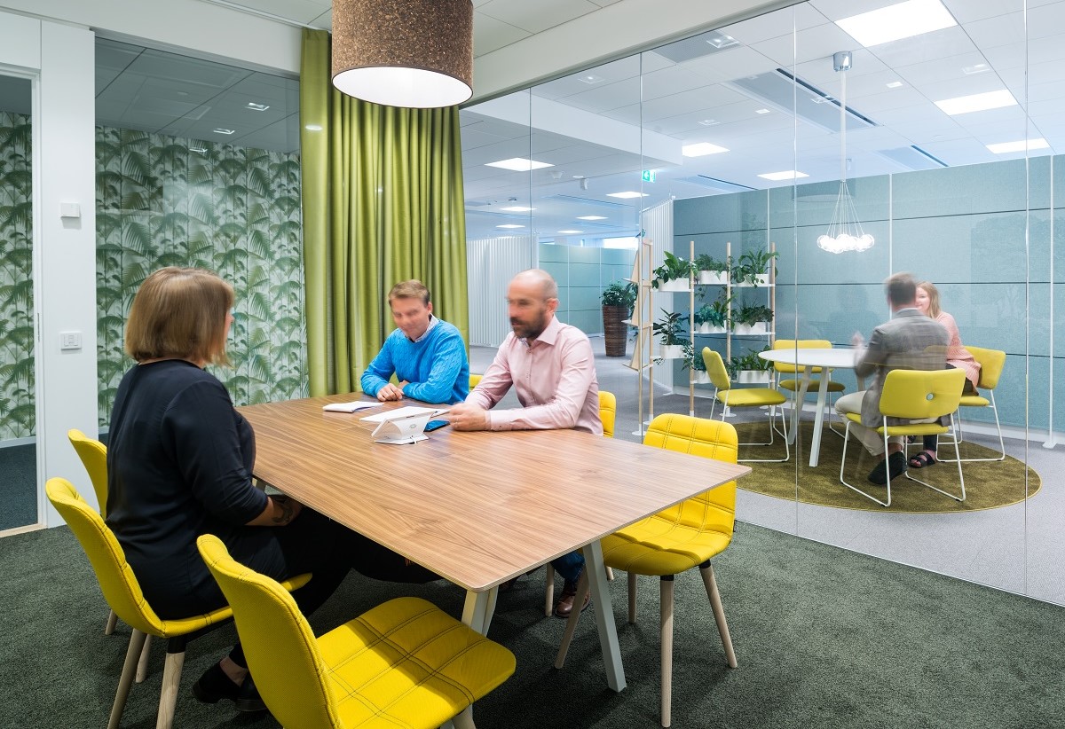 Personer sitter i ett mötesrum på ett kontor.